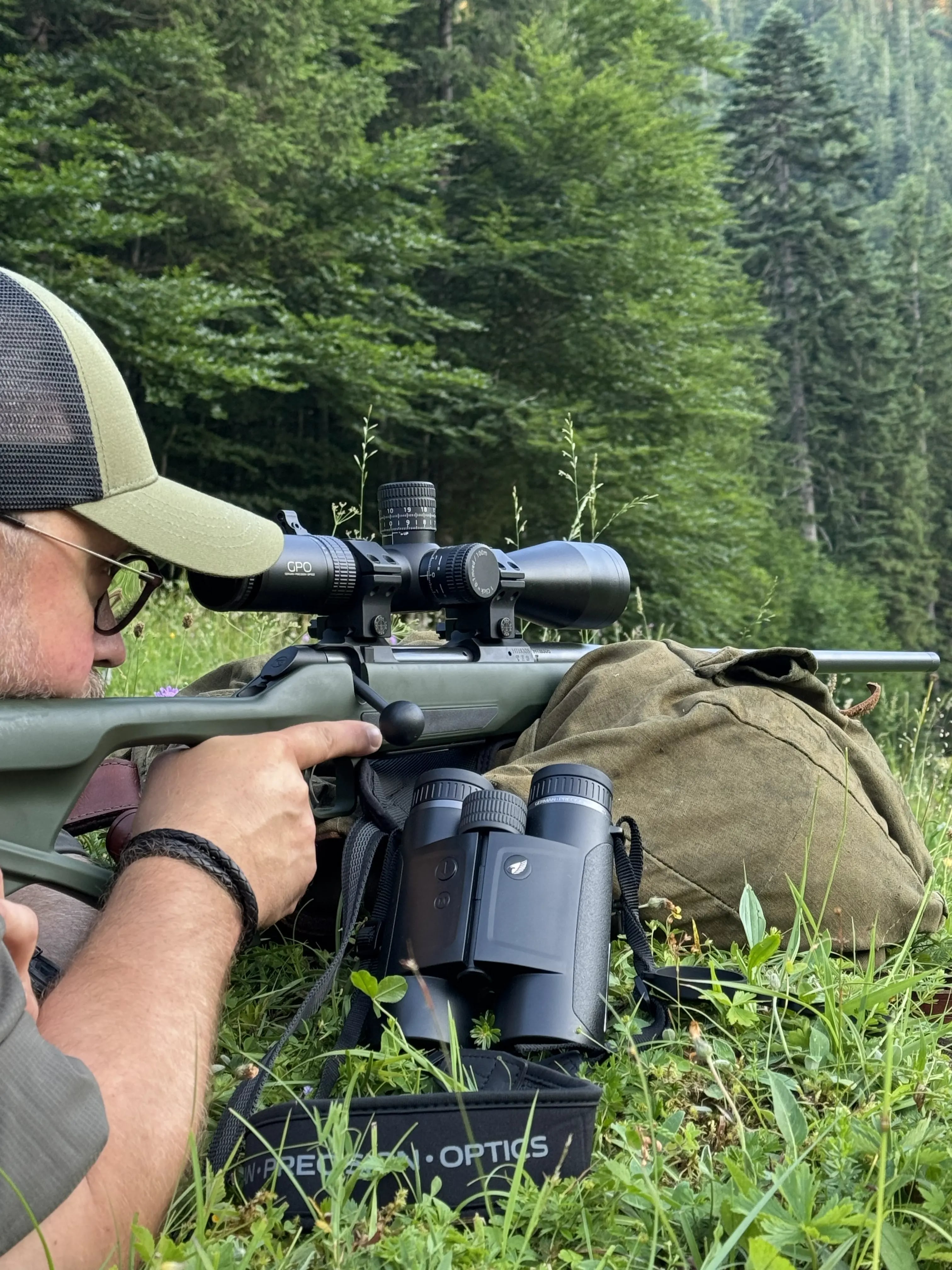 Hunting optic on hunting rifle, binoculars, backpack, nature